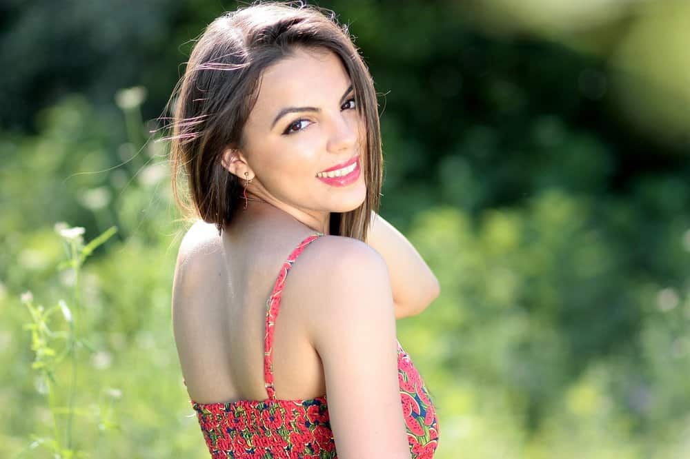 Woman with brown hair and white teeth smiling