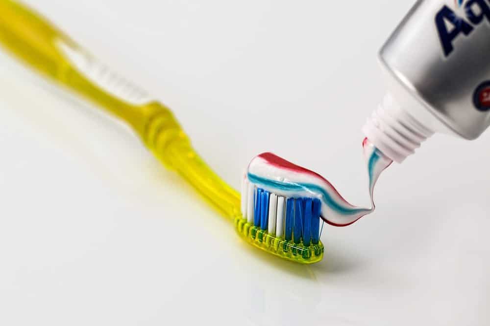 Toothpaste being squeezed onto a toothbrush
