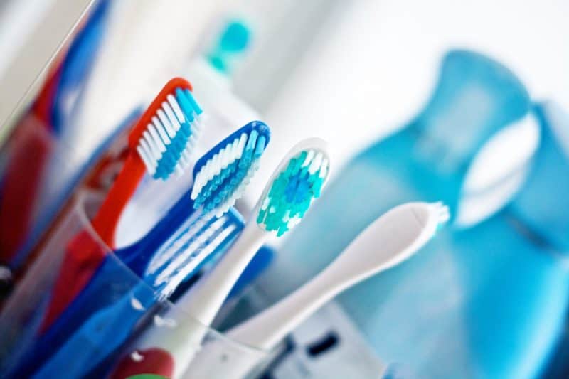 A cup full of different toothbrushes