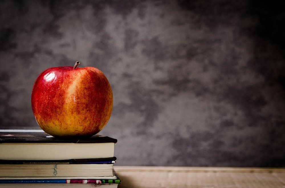 Red apple sitting on books